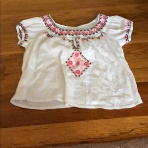 A white flowy tee, with bright colored accents.